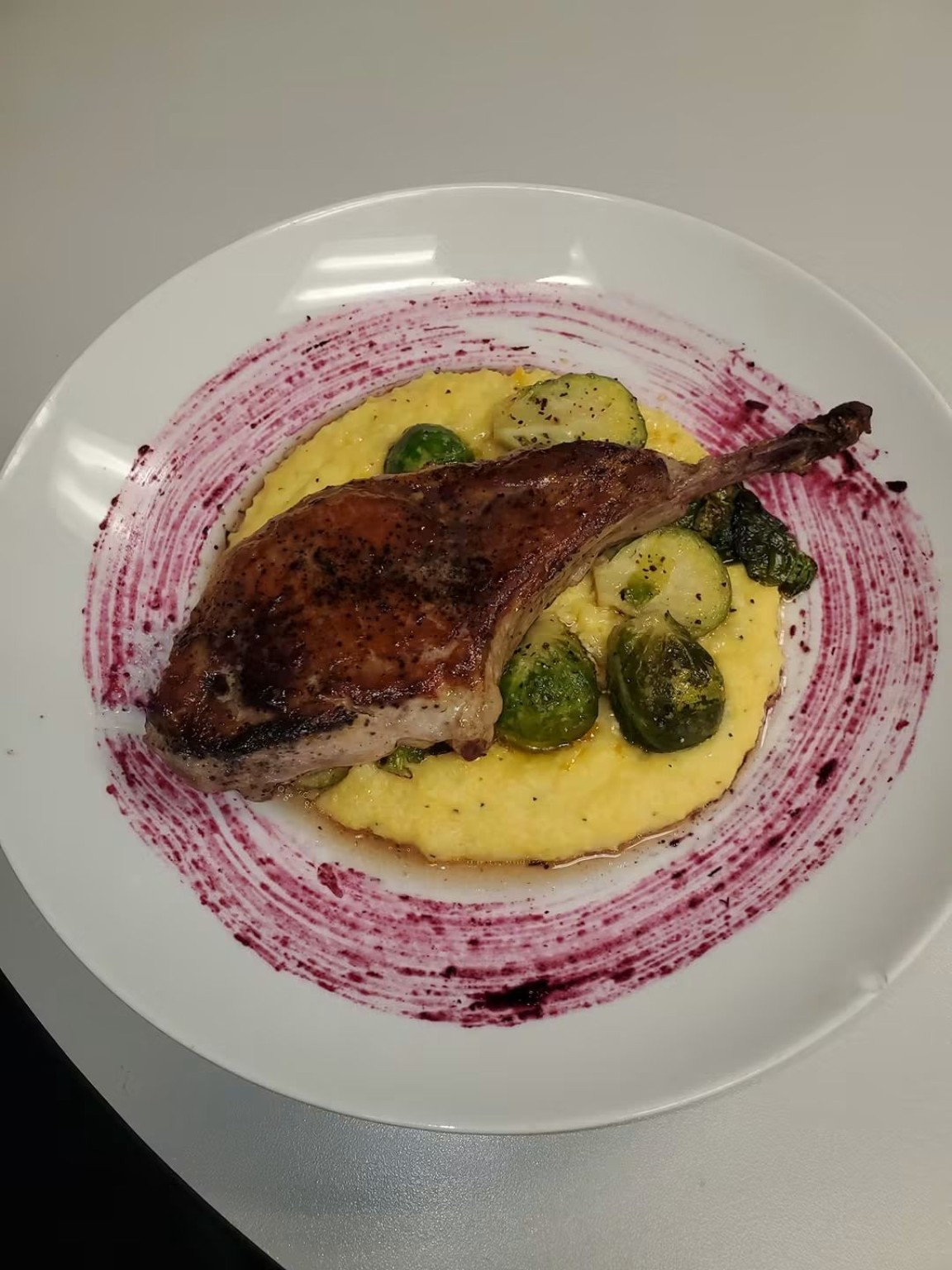 Roasted duck served over puree and vegetables