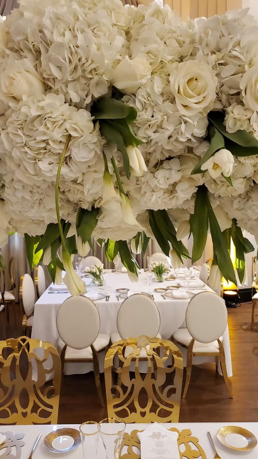 White table with tall greenery and flowers