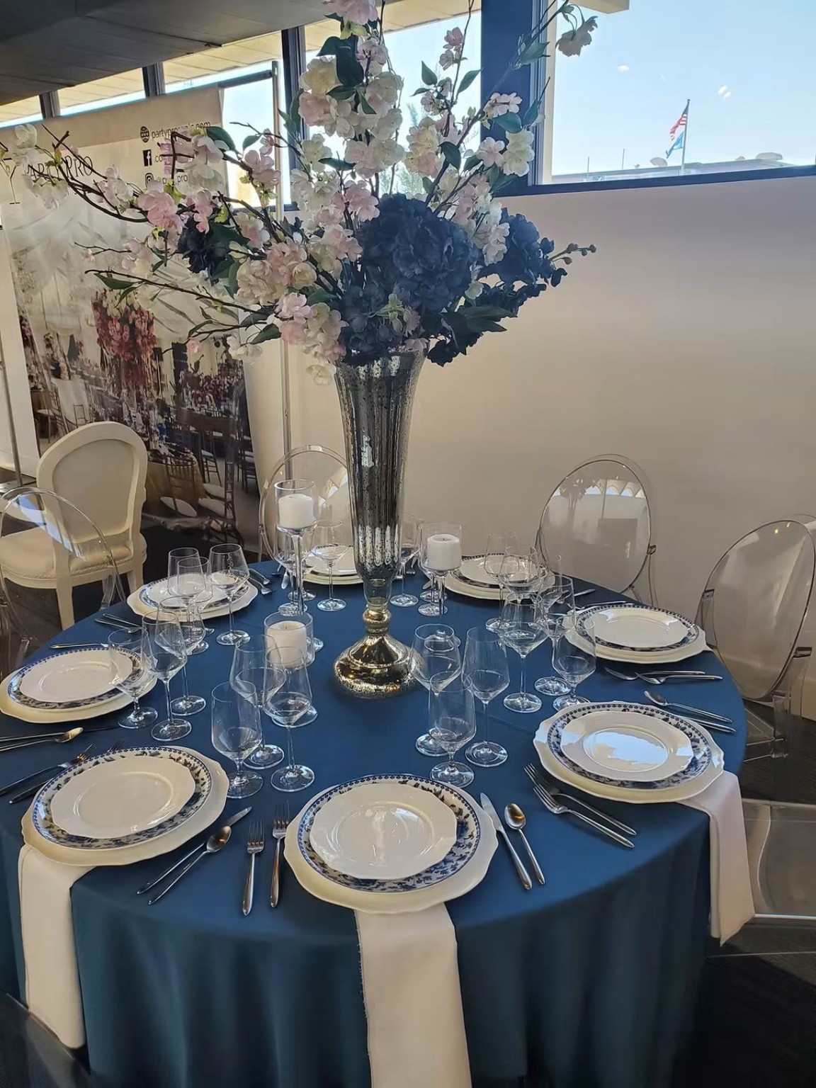 Light table setting with blue floral centerpiece
