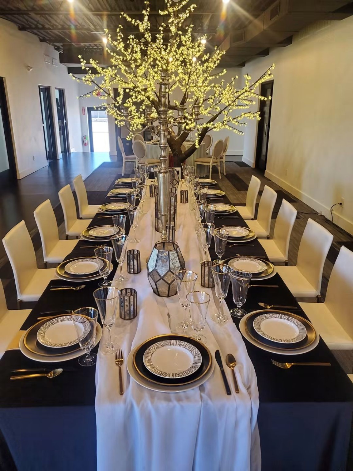 An elegant catered dining table with a lit centerpiece